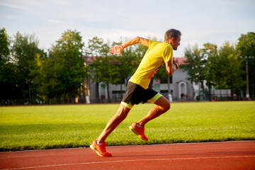 Obraz premium young runner runs stadium summer