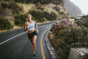 Fitness woman running on countryside highway