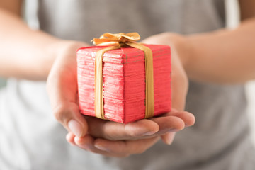 Woman holding red gift box by hand