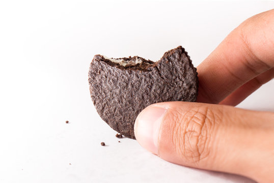 chocolate cookie with milk cream inside and human hane