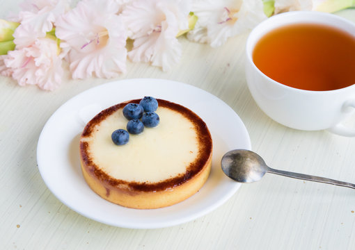 Cup of tea and cheese cake with blueberry on white background
