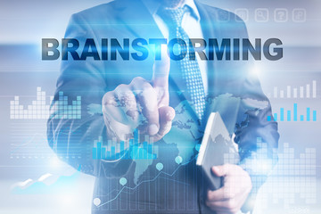 Businessman is pressing button on touch screen interface and selecting "Brainstorming".