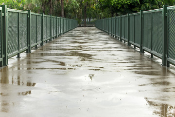 Concreate bridge with green fence wet after the rain.