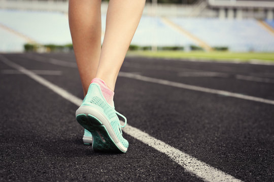 Woman wearing mint sneakers on a running stadium