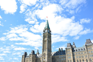 The Center Block and the Peace Tower in Parliament Hill, Ottawa, Canada. People may be seen around.