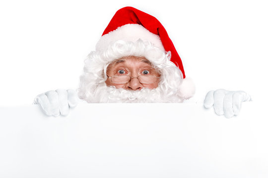 Happy New Year! Funny Santa Claus looking out of the copy space on white background