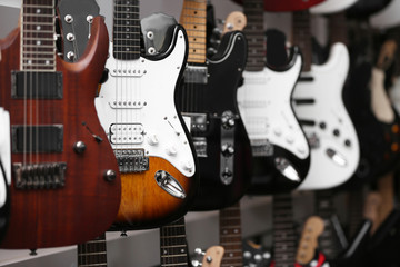 Fototapeta na wymiar Guitars hanging on wall, closeup