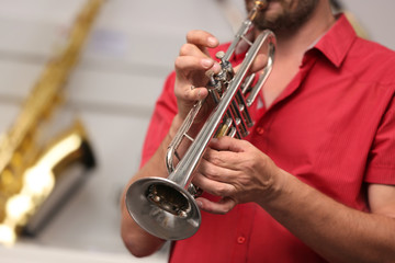 Fototapeta premium Man playing horn in music shop