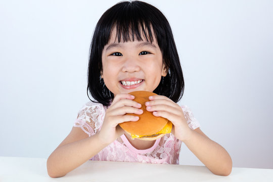 Happy Asian Chinese little girl Eating Burger