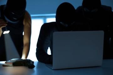 Armed thieves hacking laptop in the room