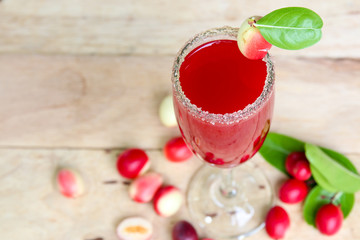 Carandas-plum  juice  in a glass on wooden background  