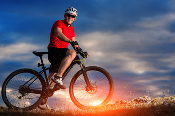 Fototapeta na wymiar mountain bicycle rider on the hill with sunrise background