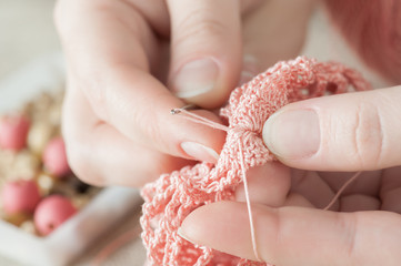 Female hands with pink knitting