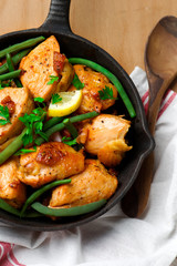 chicken breasts with a lgreen beans n a frying pan.
