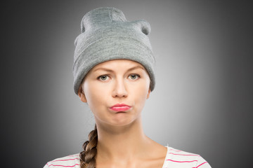 Upset young woman in winter hat