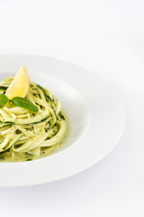 Zucchini noodles with pesto sauce isolated on white background

