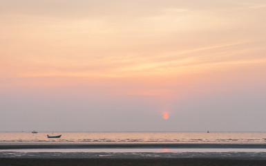 Obraz premium Sunset on the beach with fisherman’s boats background.