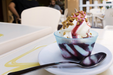 frozen yogurt with black cherry topping and amaretto grains in an outdoor cafe