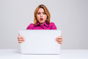 Naklejka premium young woman sitting in the table and using laptop