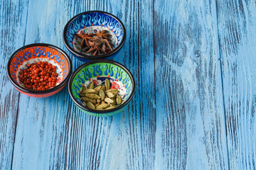 Spices in bowl on blue wooden table