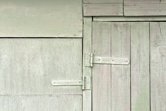 old wooden hangar door with metal hinges.