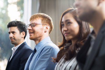 Fototapeta premium Business people listening to speaker and smiling