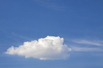 Blue sky with puffy white clouds in bright clear sunny day