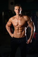 Fototapeta na wymiar Strong athletic man fitness model showing six pack abs