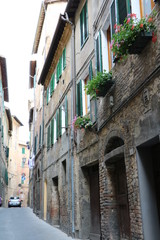 Old typical narrow alley in Siena, Tuscany Italy