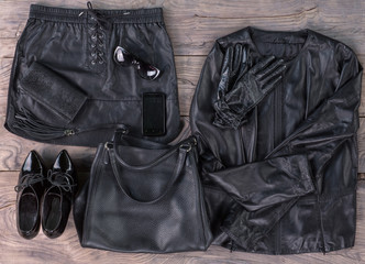 black leather women's things and other accessories on a wooden surface