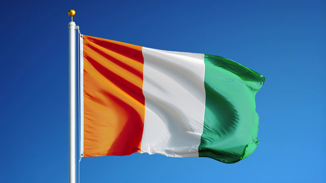 Cote Ivoire flag waving against clean blue sky, close up, isolated with clipping path mask alpha channel transparency