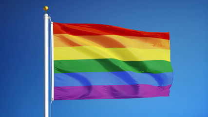 The gay pride rainbow flag waving against clean blue sky, close up, isolated with clipping path...