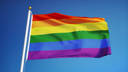The gay pride rainbow flag waving against clean blue sky, close up, isolated with clipping path mask alpha channel transparency
