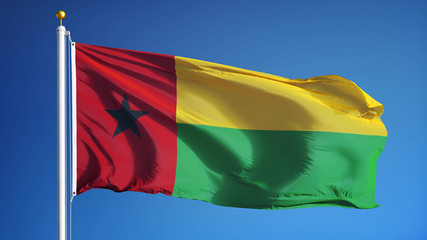 Guinea Bissau flag waving against clean blue sky, close up, isolated with clipping path mask alpha channel transparency