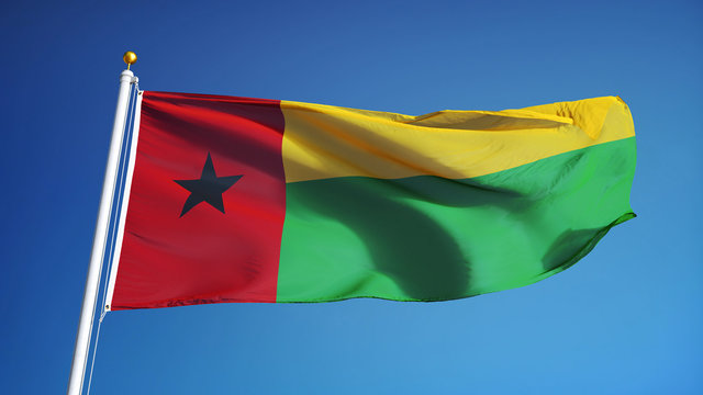 Guinea Bissau flag waving against clean blue sky, close up, isolated with clipping path mask alpha channel transparency