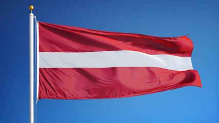 Obraz na płótnie Canvas Latvia flag waving against clean blue sky, close up, isolated with clipping path mask alpha channel transparency