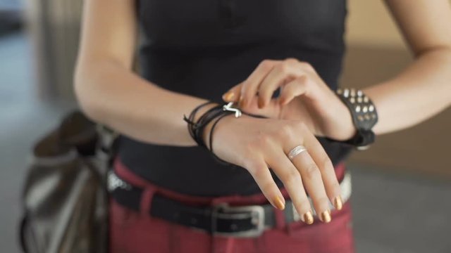 Punk girl touching her bracelet with studs and thong
