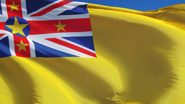 Niue flag waving against clean blue sky, close up, isolated with clipping path mask alpha channel transparency