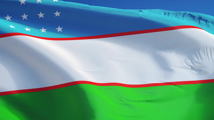 Uzbekistan flag waving against clean blue sky, close up, isolated with clipping path mask alpha channel transparency