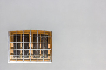 window with bars on a gray wall 