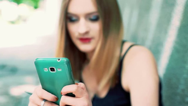 Happy, punk girl browsing internet on smartphone
