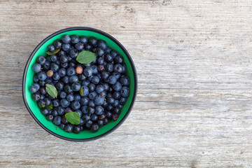 Blueberry in a bowl from above on a plank