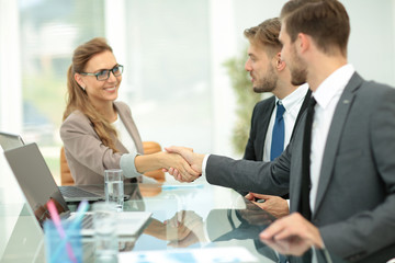 Fototapeta premium Happy business partners shaking hands in an office