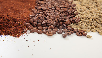 Green and dark coffee beans and ground coffee