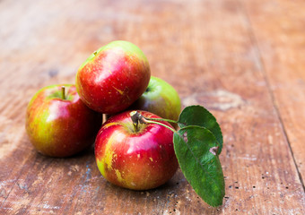 Red ripe apples at dark wooden table.