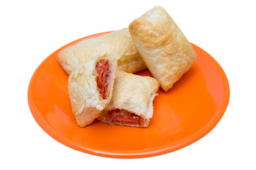 Puff pastry appetizers with salami and cheese on a white background