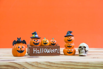 Halloween decoration on wooden table over orange background