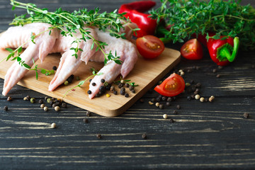 Raw chicken wings with thyme, chili, pepper and tomatoes
