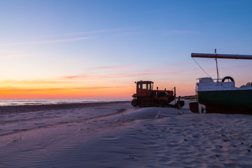 Fishing boat and tractor at sunset