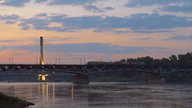 Swietokrzystki bridge at night with reflection in the Vistula river in Warsaw, Poland